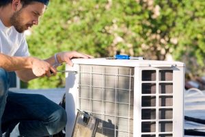 Photo of a man working on a heat pump
