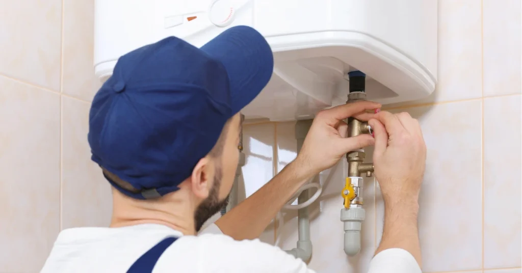 Professional plumber installing heat pump water heater demonstrating energy efficient heating system for residential use