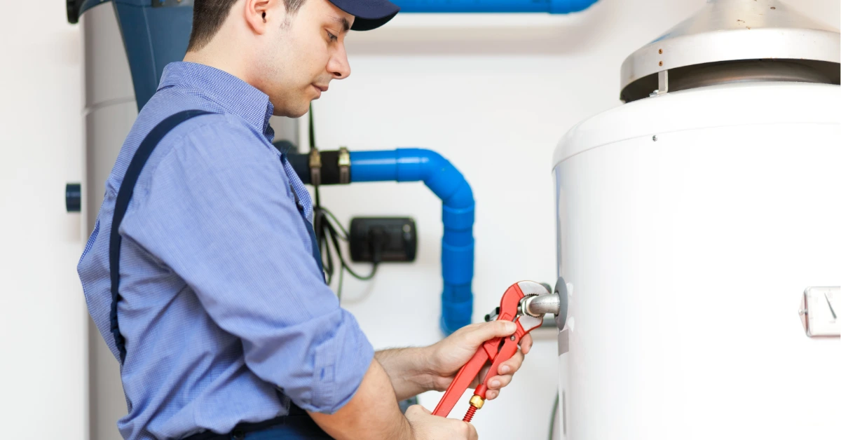 Plumber examining heat pump water heater components showing how the energy efficient system works