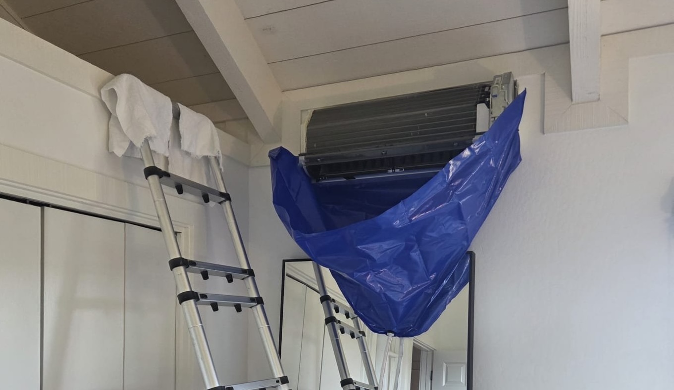 Bellows HVAC technician cleaning a ductless mini split indoor unit coil and drain pan in a San Jose home