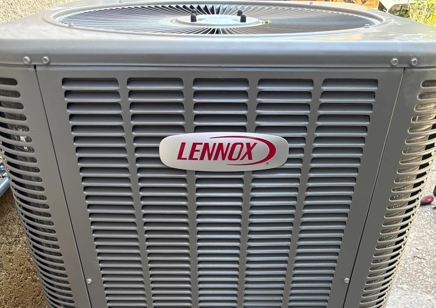 HVAC technician inspecting air conditioner unit at San Jose home in summer