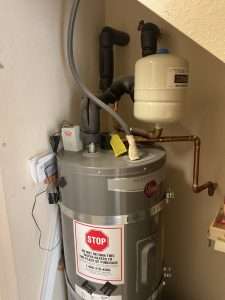 Bellows technician installing a heat pump water heater in a Bay Area garage ahead of the zero-NOx rule deadline