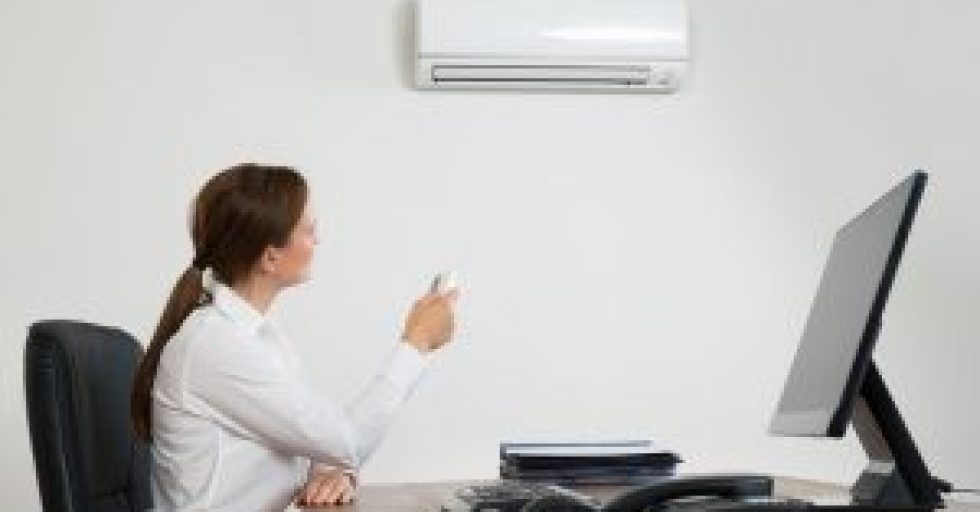 45461332 - young businesswoman using remote control in front of air conditioner mounted on wall